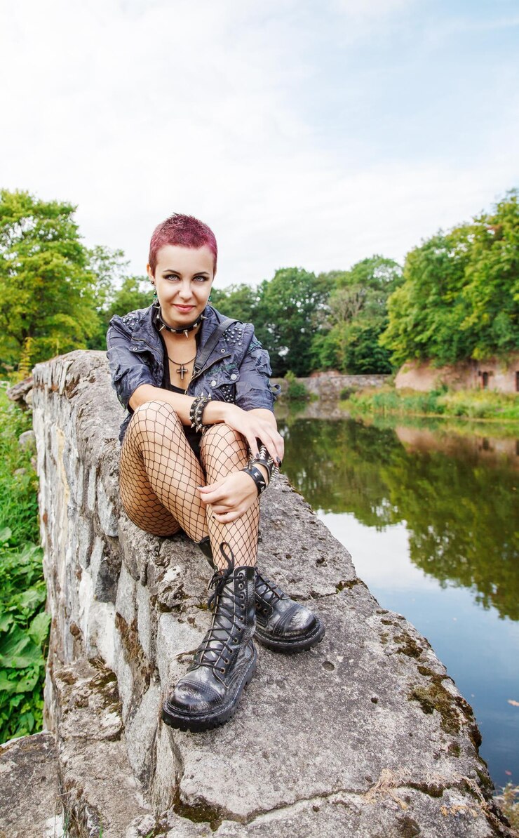Photo portrait of young woman sitting on rock by lake against sky
