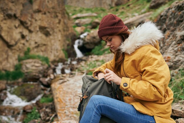 Portrait of young woman sitting on rock