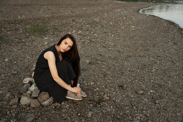 Photo portrait of young woman sitting on rocks