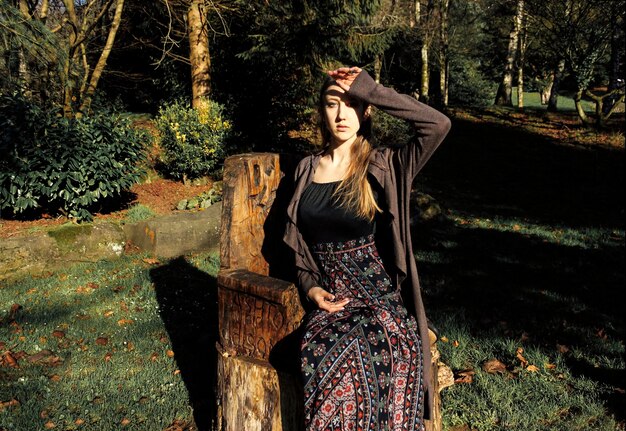 Photo portrait of young woman sitting on seat in forest