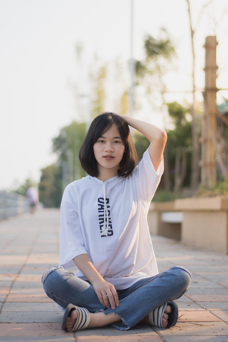 Photo 坐在人行道上的年轻女人的肖像