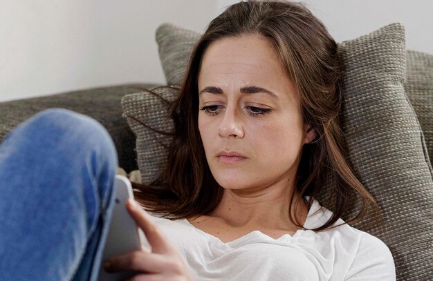 Portrait of young woman sitting on sofa at home