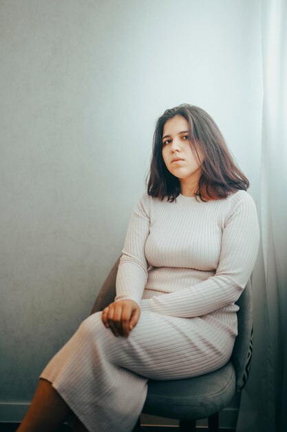 Photo portrait of young woman sitting on sofa at home