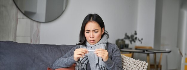 Portrait of young woman sitting on sofa at home