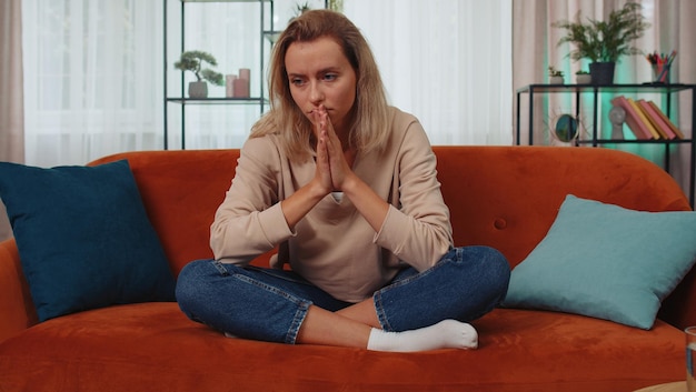 Portrait of young woman sitting on sofa at home