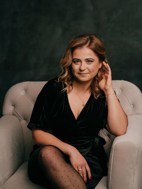 Photo portrait of young woman sitting on sofa