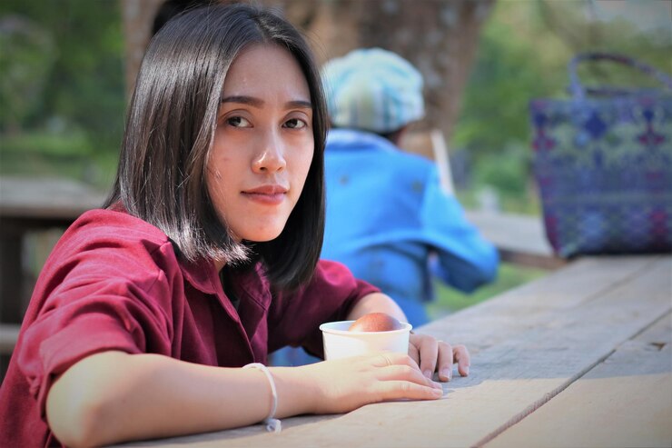 Photo テーブルに座っている若い女性の肖像画