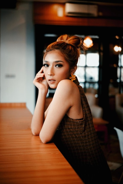 Photo portrait of young woman sitting on table