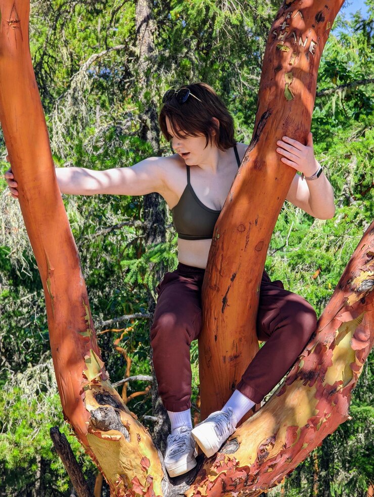 Photo portrait of young woman sitting in a tree