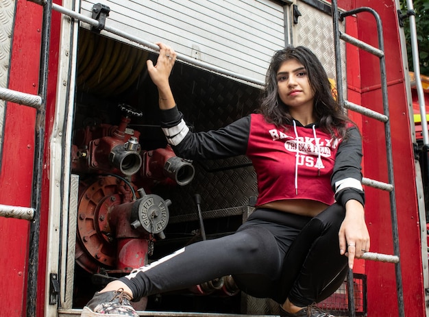 Portrait of young woman sitting on a truck outdoors