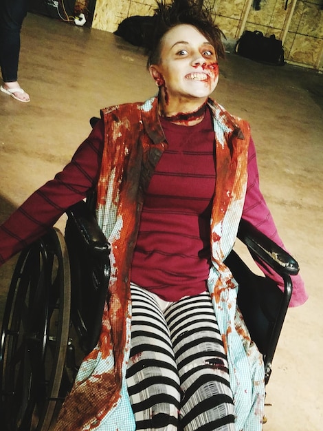 Photo portrait of young woman sitting on wheelchair with halloween make-up