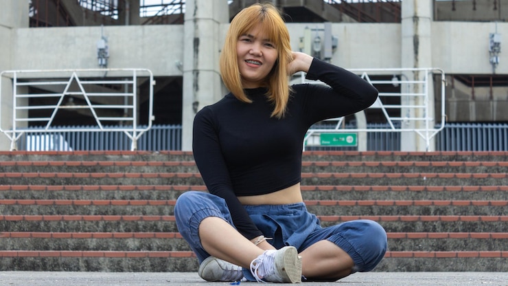 Photo 建物の向こうの階段に座っている若い女性の肖像画