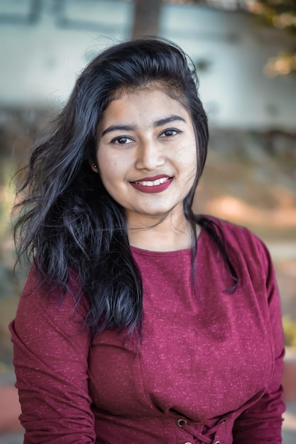 Photo portrait of young woman smiling while standing outdoors