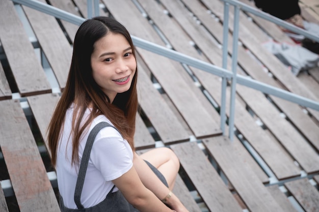 Photo portrait of young woman smiling while standing at stadium