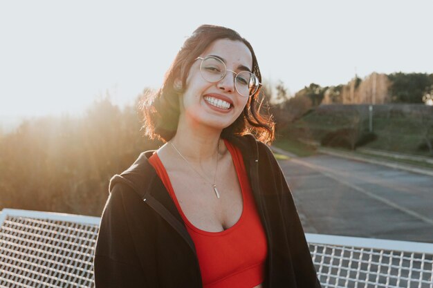 Portrait of young woman on sport clothes after a workout training outdoors happy lifestyle sport Portrait of happy fit people Sport people workout concept during sunset super smile and glasses