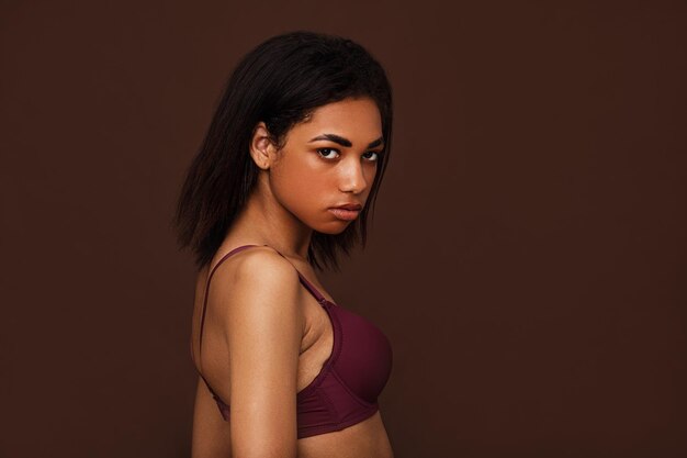 Photo portrait of young woman standing against black background