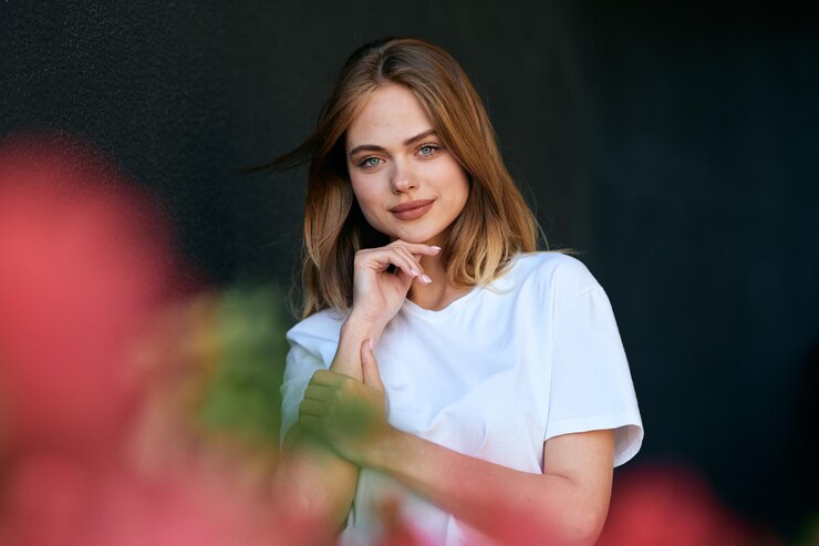 Фотография портрет молодой женщины, стоящей на черном фоне