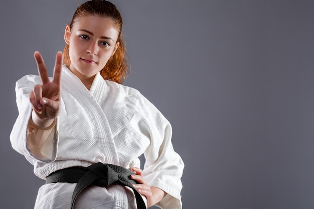 portrait of young woman standing against black background