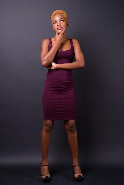 Photo portrait of young woman standing against black background