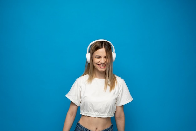 Portrait of young woman standing against blue background