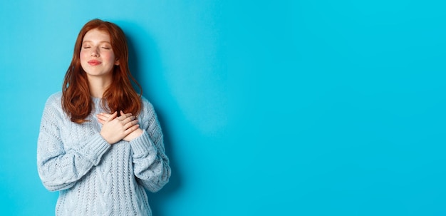 Foto ritratto di una giovane donna in piedi su uno sfondo blu