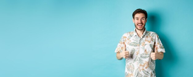 Portrait of young woman standing against blue background