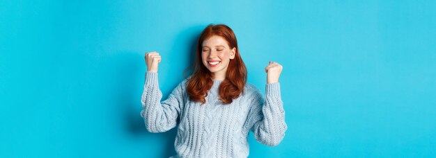 Photo portrait of young woman standing against blue background