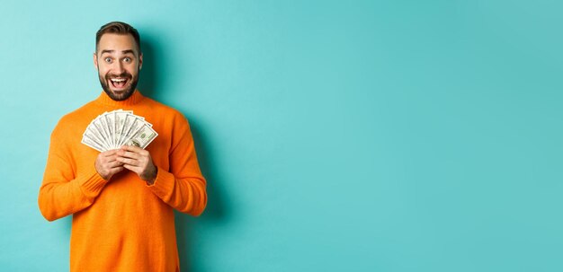 Portrait of young woman standing against blue background