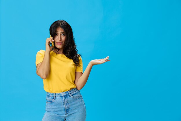 Portrait of young woman standing against blue background