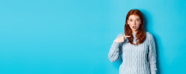 Foto ritratto di una giovane donna in piedi su uno sfondo blu