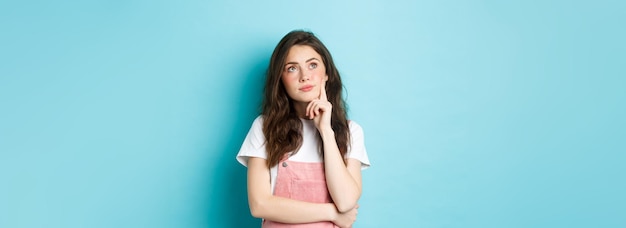 Photo portrait of young woman standing against blue background