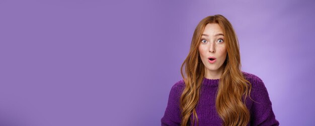 Portrait of young woman standing against blue background