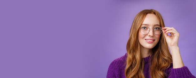 Portrait of young woman standing against blue background