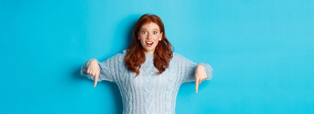 Photo portrait of young woman standing against blue background