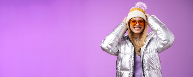 Portrait of young woman standing against blue background