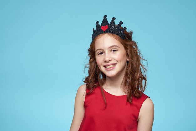 Portrait of young woman standing against blue background