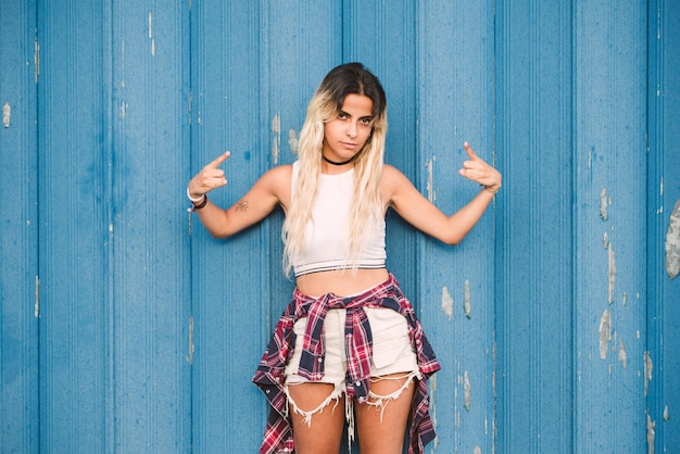 Photo portrait of young woman standing against blue wall