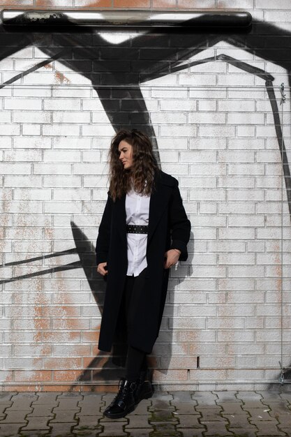 Photo portrait of young woman standing against brick wall