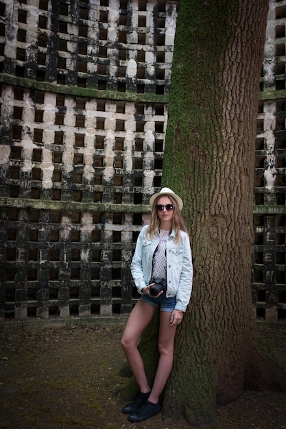 Портрет молодой женщины, стоящей у кирпичной стены