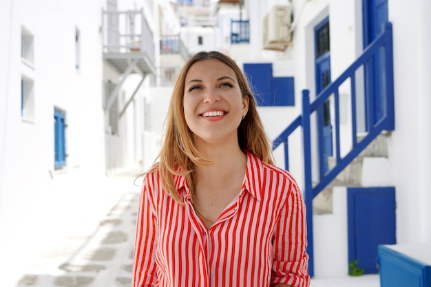 Portrait of young woman standing against building