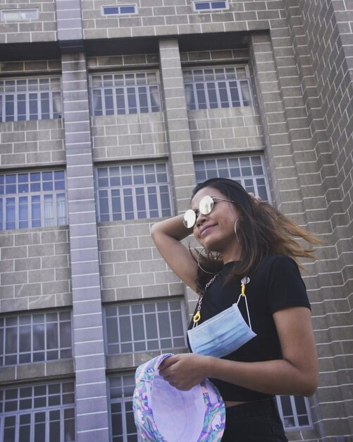 Foto ritratto di una giovane donna in piedi contro un edificio