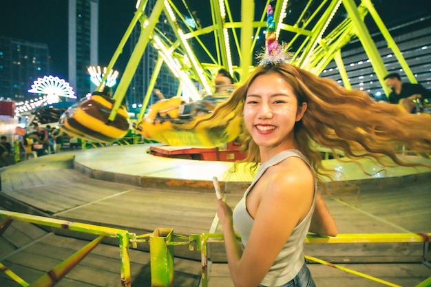 Photo portrait of young woman standing against chain swing ride