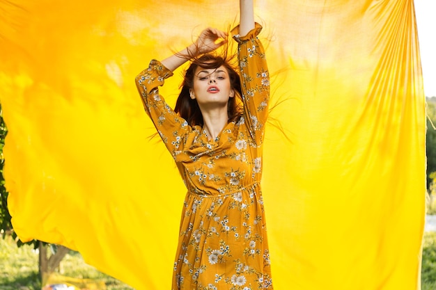 Portrait of young woman standing against curtain