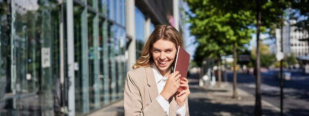 Portrait of young woman standing against fence