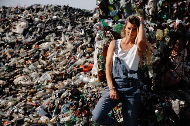 Photo portrait of young woman standing against garbage heap