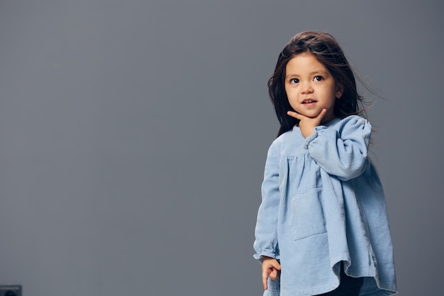 Photo portrait of young woman standing against gray background