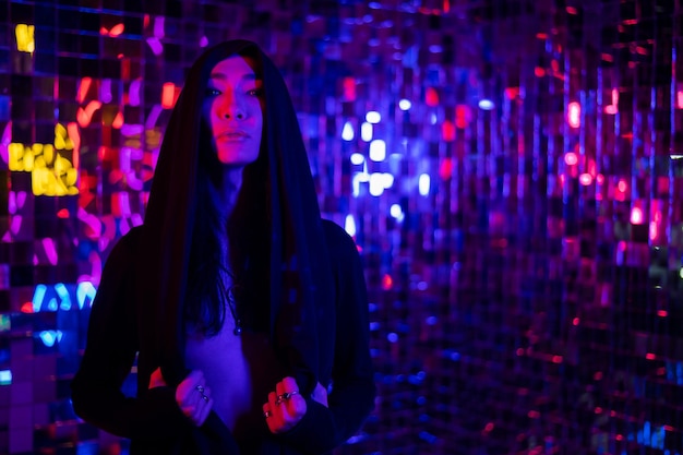 Portrait of young woman standing against illuminated lights