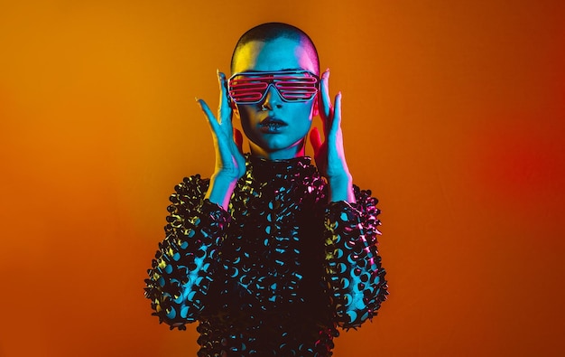 Portrait of young woman standing against orange background