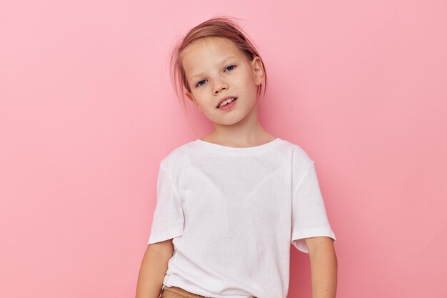 Portrait of young woman standing against pink background