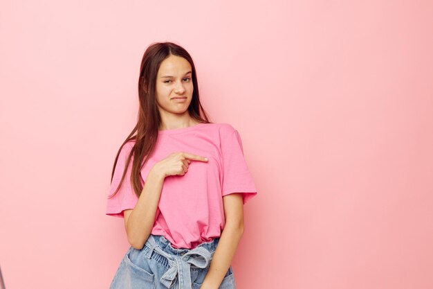 Photo portrait of young woman standing against pink background